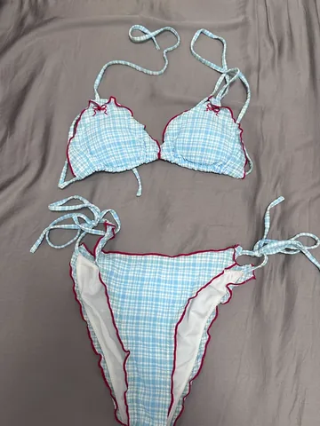 Gingham bikini set shot on a phone, on a crumpled bedsheet in warm indoor light