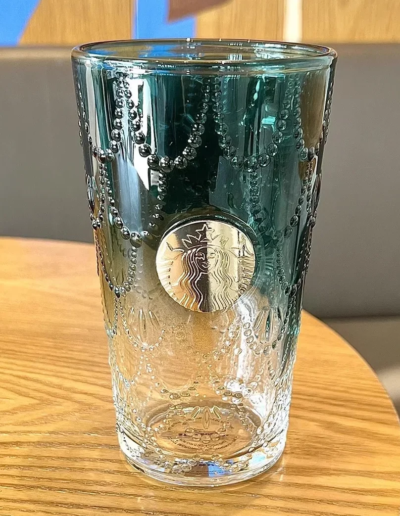 Textured glass tumbler shot on a phone with window reflections across the surface