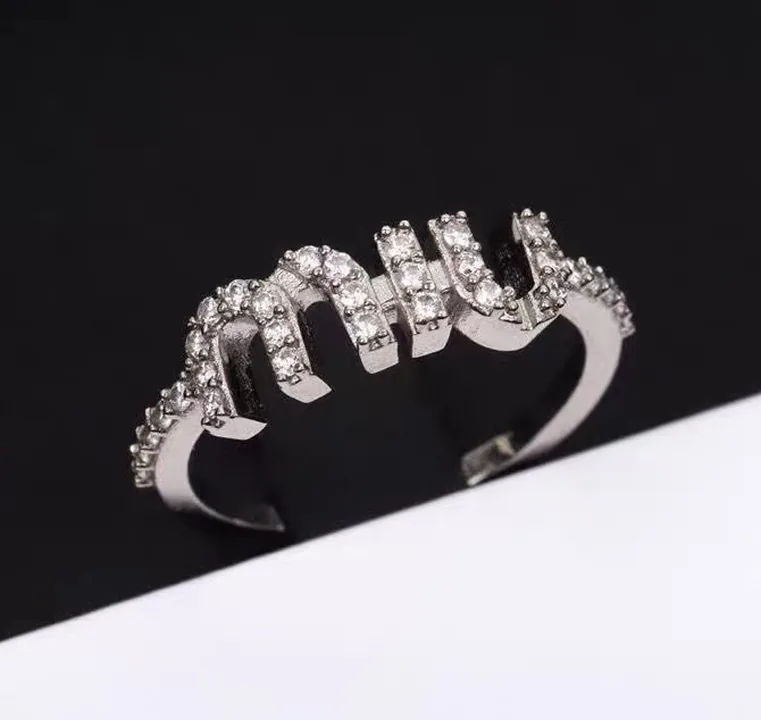 Pavé nameplate ring shot on a phone against a dark background