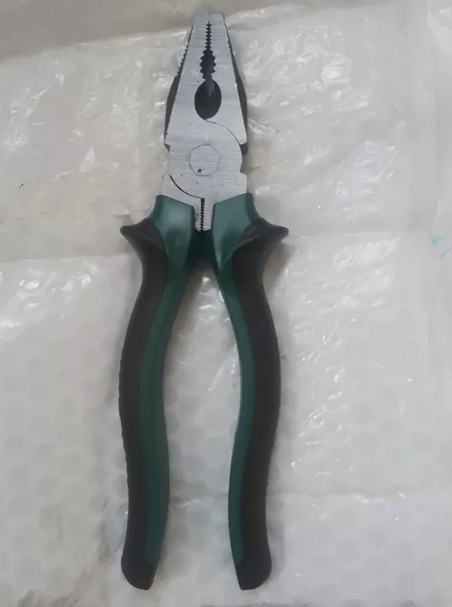Green-handled pliers shot on a phone on bubble wrap in mixed indoor light