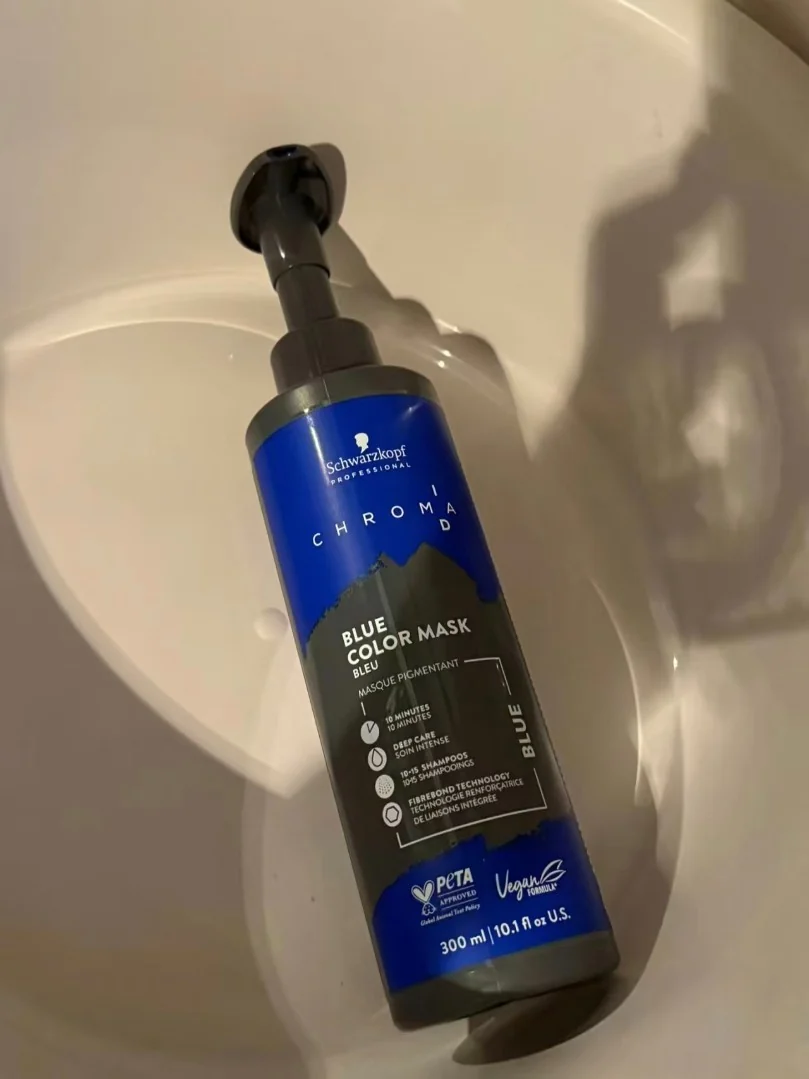 Blue color mask shampoo bottle shot on a phone in a bathroom sink with warm light and hard shadows