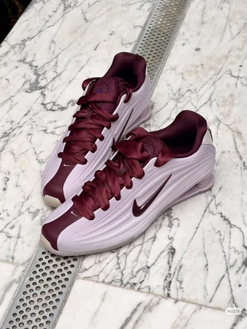 Pink and burgundy Nike Shox sneakers shot on a phone, on a marble surface