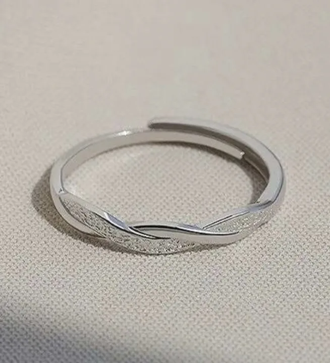 Frosted twist silver band ring shot on a phone on a woven fabric surface